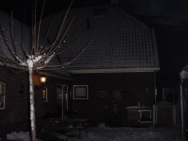 De achterkant van het huis bij nacht in de winter